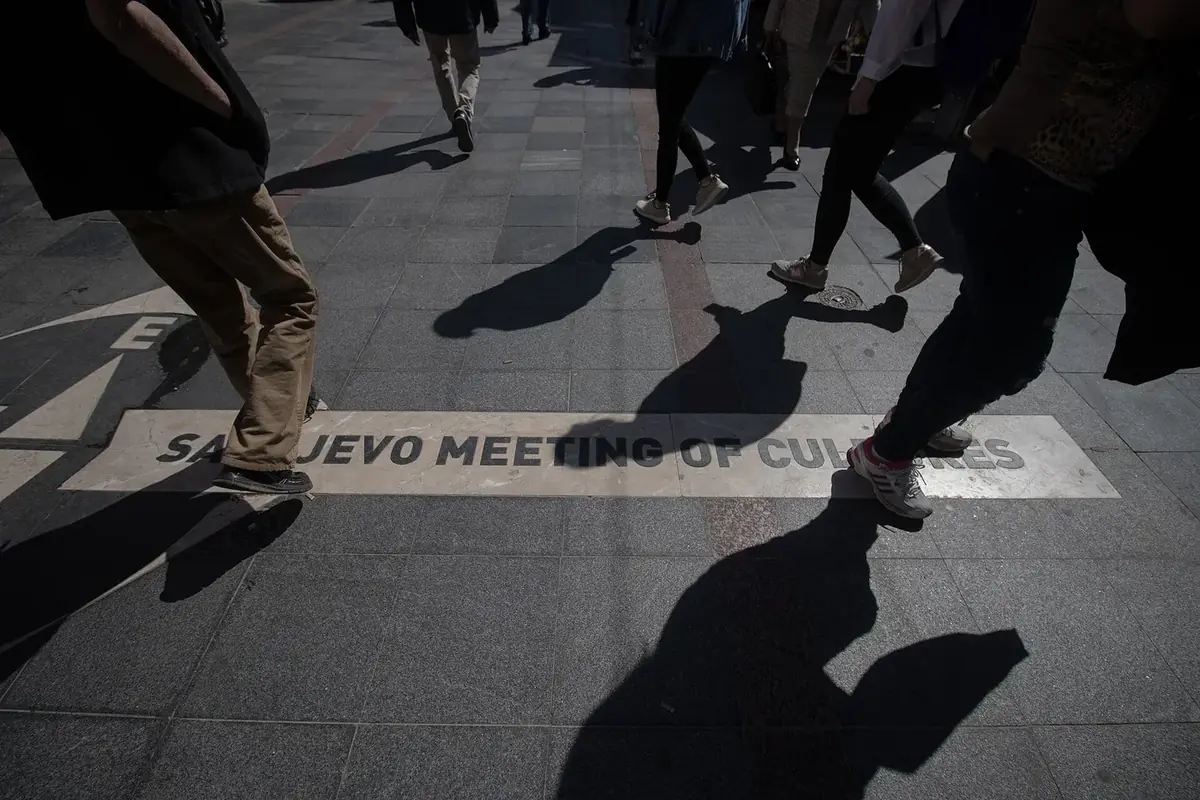The Sarajevo Meeting of Cultures marker set into the pavement of Ferhadija street, with people walking over it