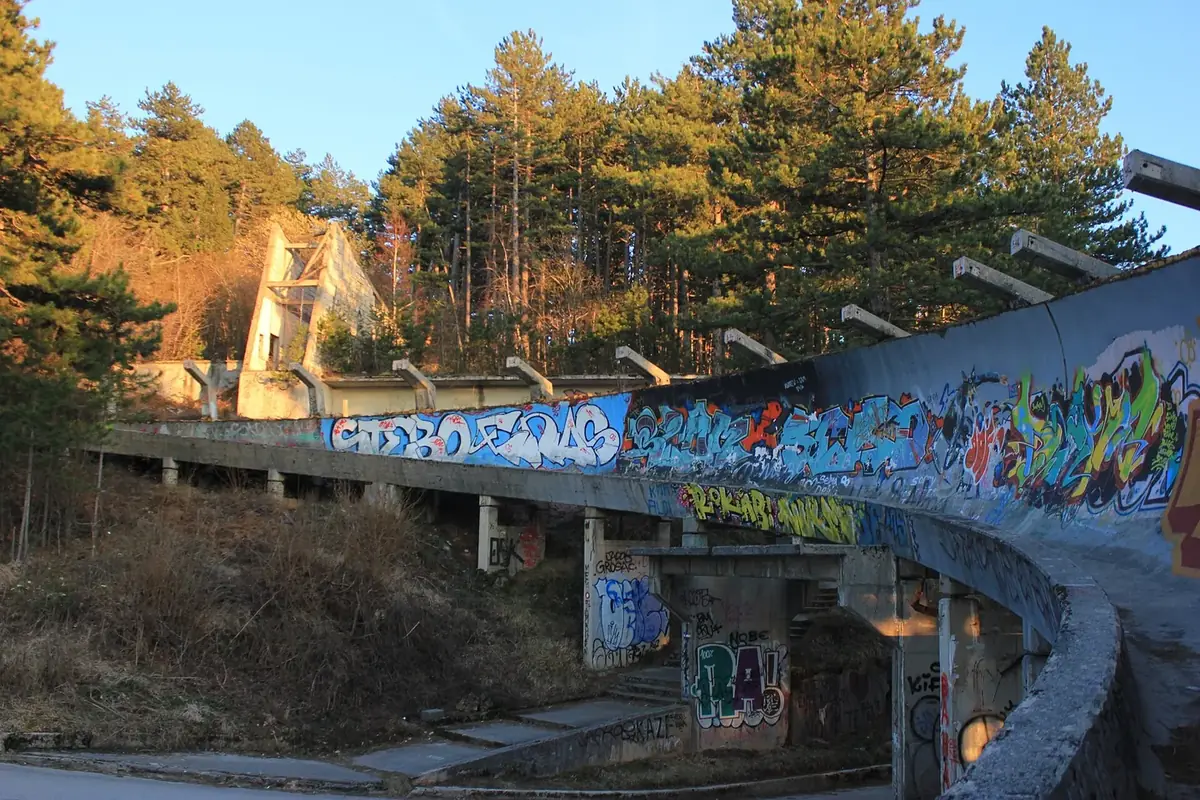 The old 1984 Olympic bobsleigh track on Trebević, a curved concrete run covered in graffiti among pine trees