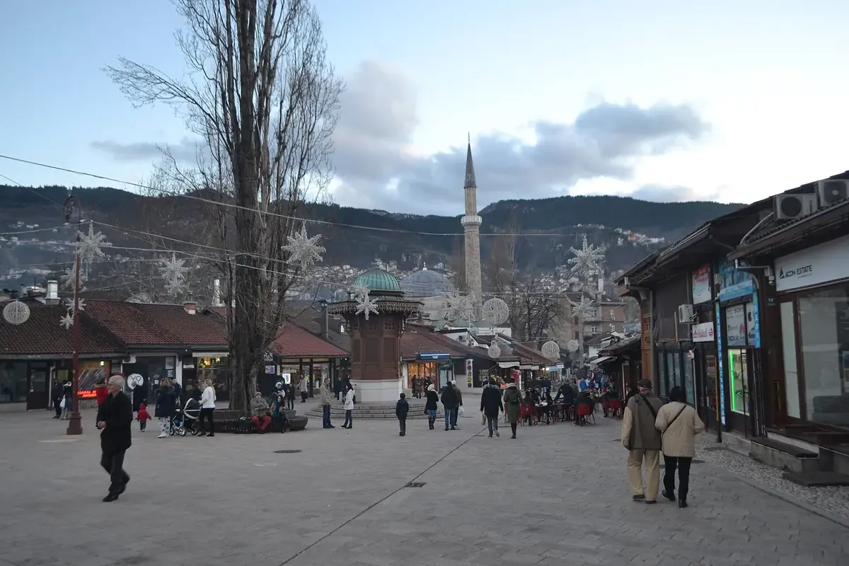 Baščaršija square in Sarajevo with the wooden Sebilj fountain and a minaret behind it