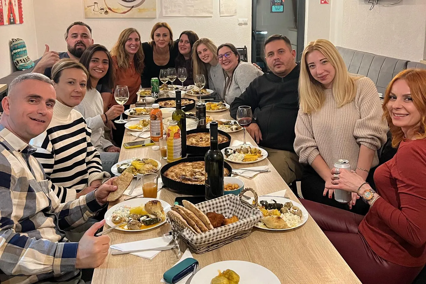 A big group of guests round one long dinner table