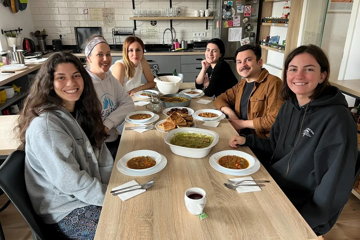 Guests smiling round the big table in our kitchen