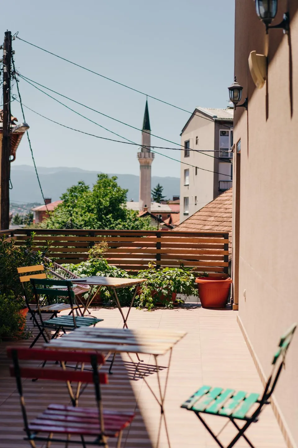 Tables on our terrace, with a minaret and the hills behind