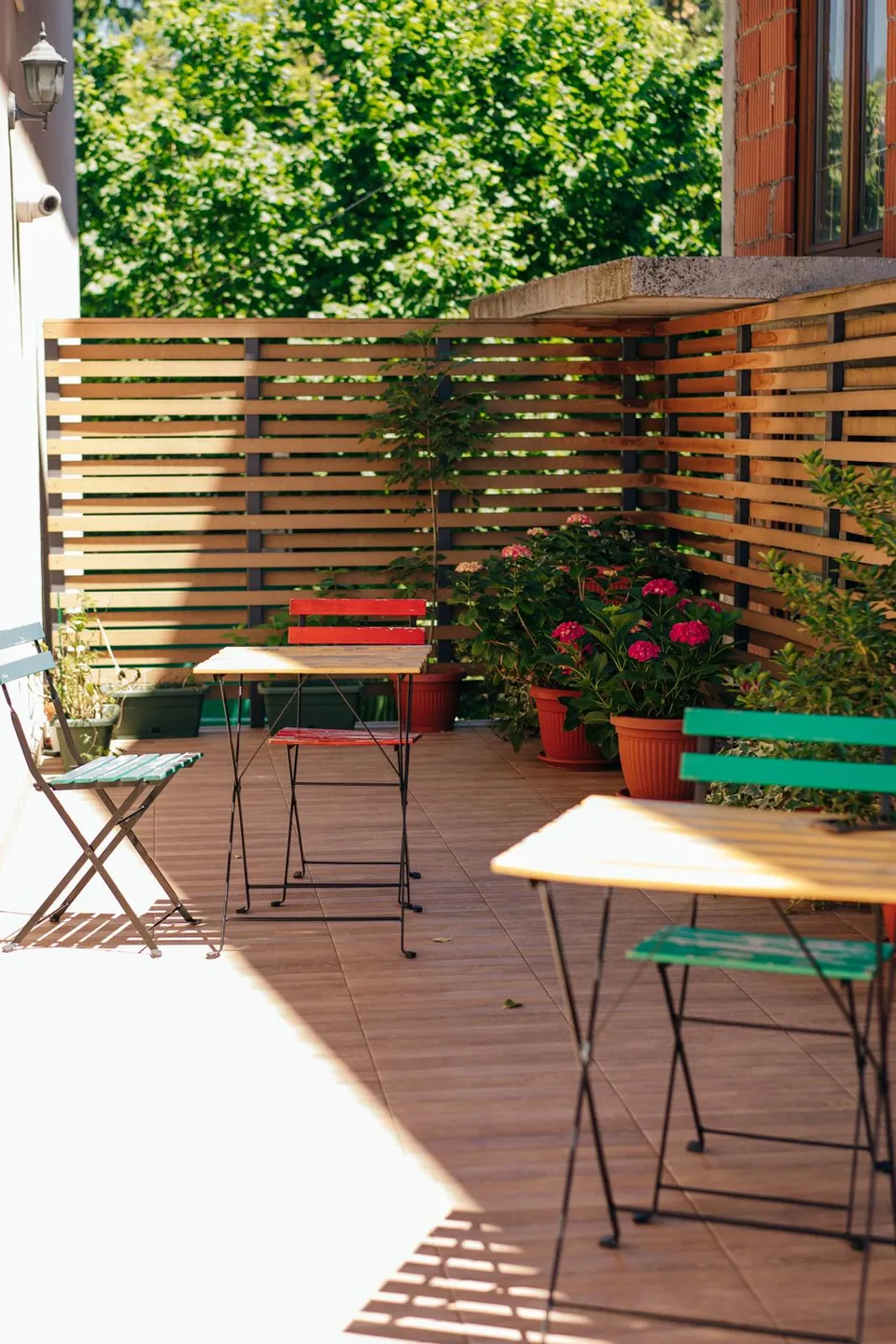 Tables, chairs and pots of flowers on our sunny terrace