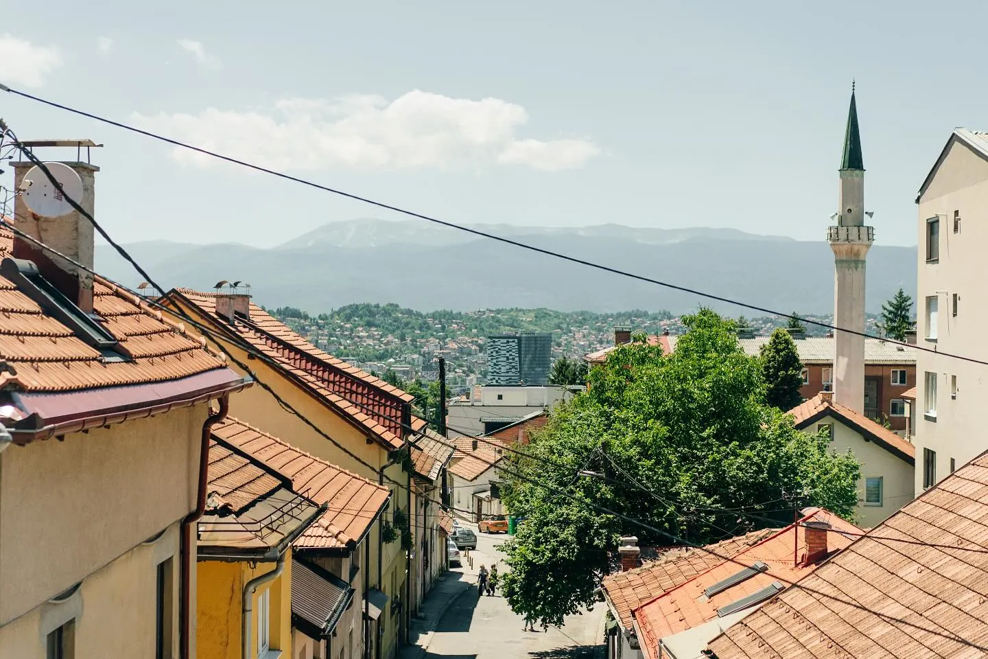 The view from the hill: red roofs down our street, a minaret and the mountains