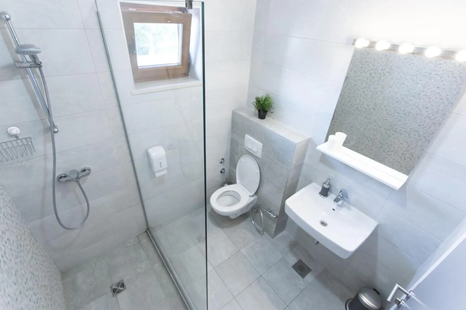 A clean shower room with a big mirror